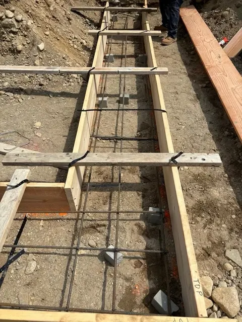 Footing forms with rebar in the excavation.