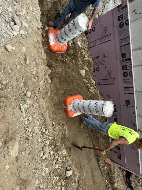 Crew setting pier forms beside the foundation.