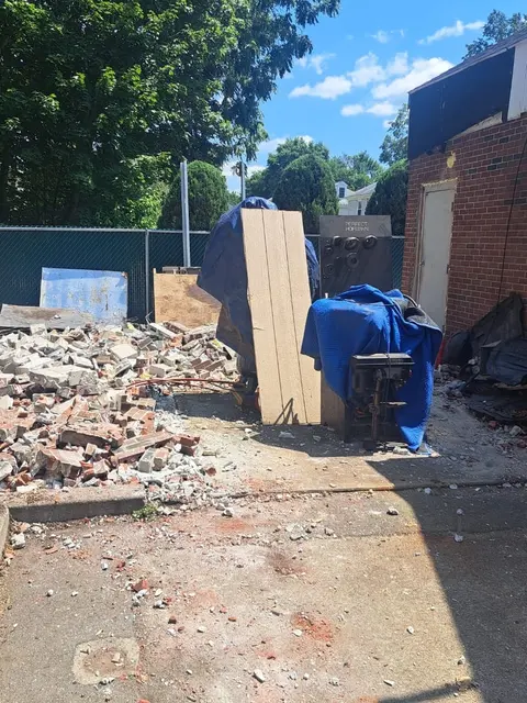 Brick debris cleared from beside a building.