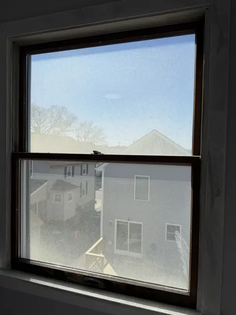 An old double-hung window with fogged glass.