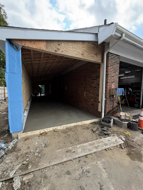 A framed and sheathed addition built onto a brick building, ready for finishes.