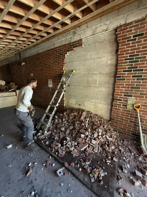 Taking down the old brick face of a wall to open it up for an addition.