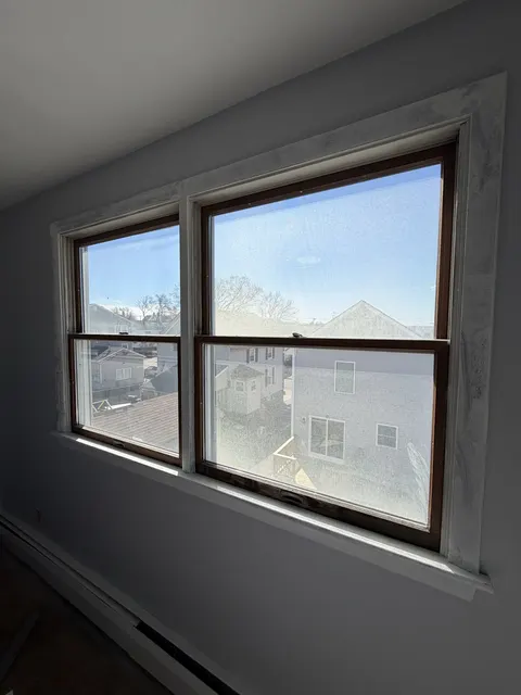 Old double-hung windows with fogged glass, before replacement.