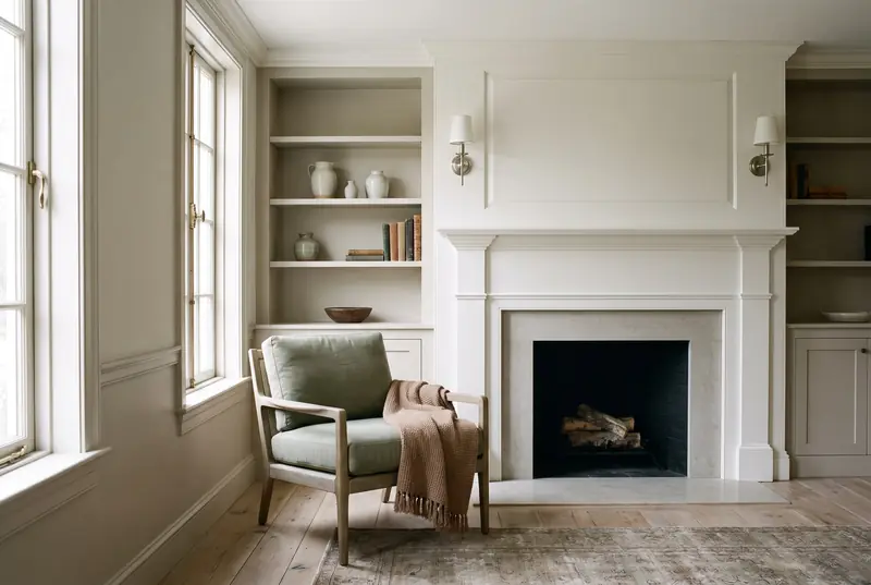 The same room after remodeling, with oak floors, painted trim and a new fireplace surround.